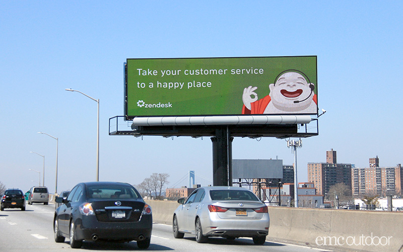 A picture containing a billboard next to highway

