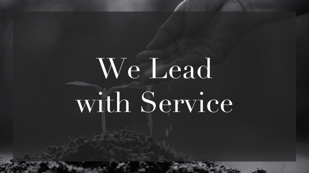 An image of a hand watering a plant with text of a core value "we lead with service"