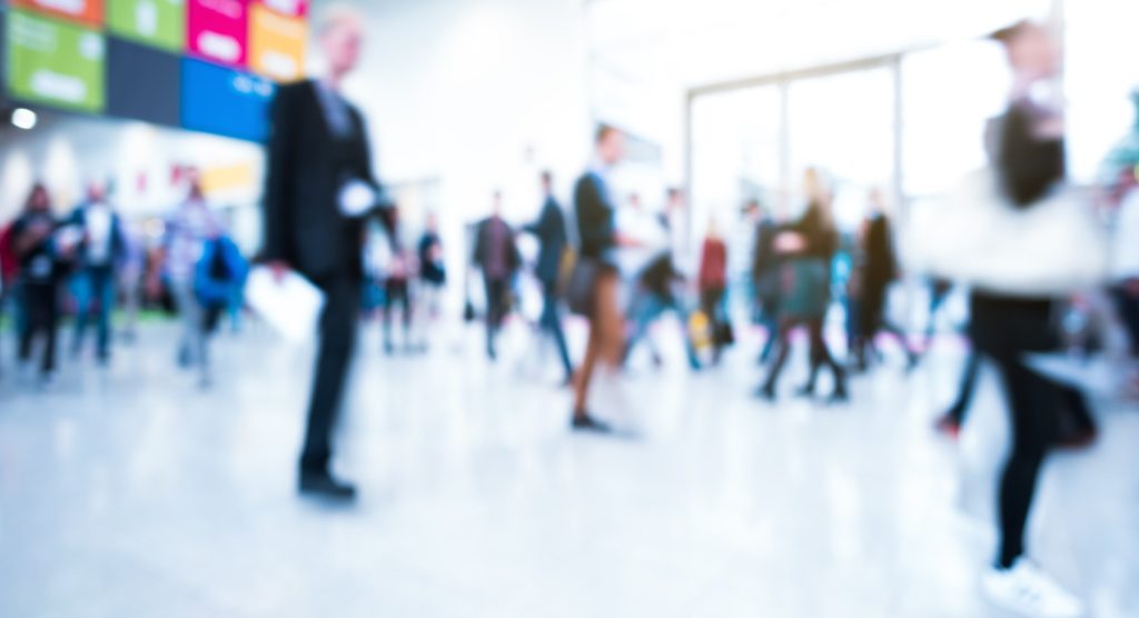 An image of conference attendees walking through a busy convention center