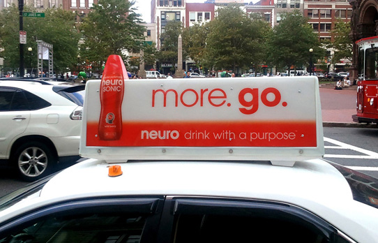 Image of a taxi advertising in Boston for a beverage product