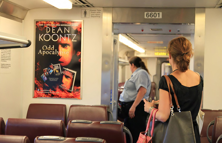 Image of a commuter rail interior advertising display for a major book release