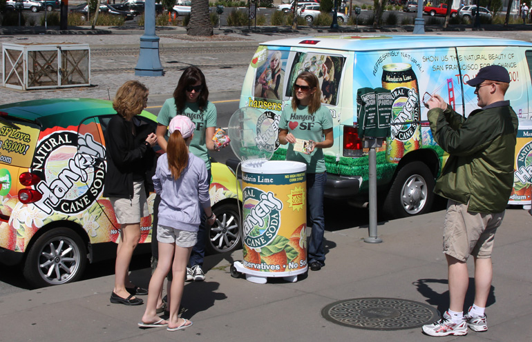 Image of a street team with wrapped vehicles distributing beverage samples